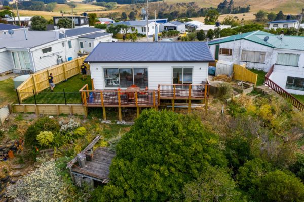 Drone photo of newly renovated bach with new exterior cladding, deck and double glazing