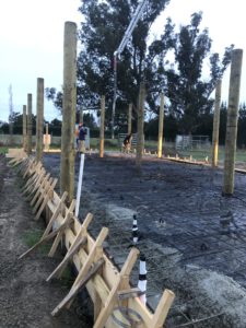 Reinforced steel foundation early morning while concrete is being pumped and spread by Code Construction. Large six bay shed build in oburn