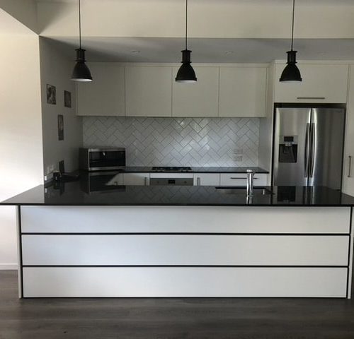 Photo of kitchen designed and built by Code Construction featuring herringbone tile splashback