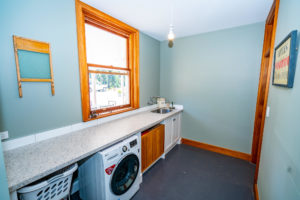 Laundry renovation completed by Code Construction. Features new bench and sink as well as tiling and paint