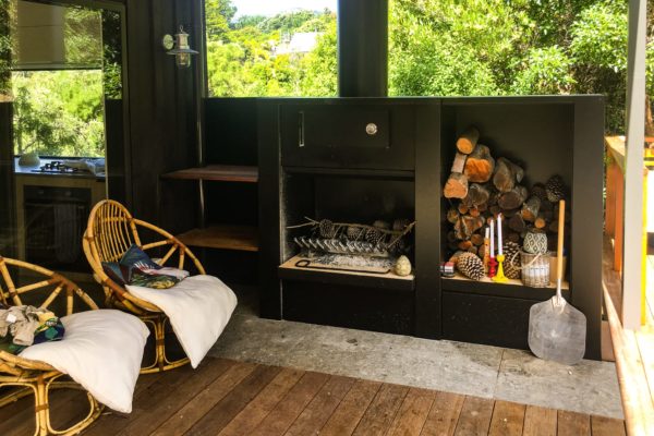 Newly renovated outdoor area in Akaroa featuring outdoor fire and wood storage