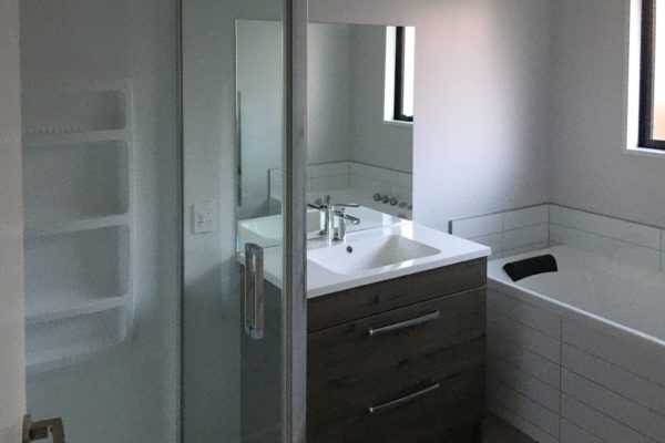 New bathroom including bath, shower and sink unit by Code Construction within new build in Rangiora