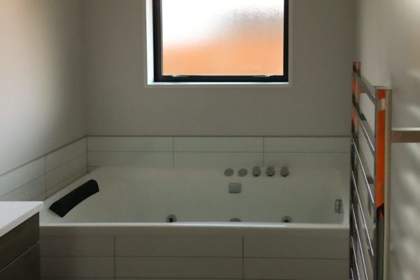 New bathroom in new build by Code Construction, includes spa bath and tiling