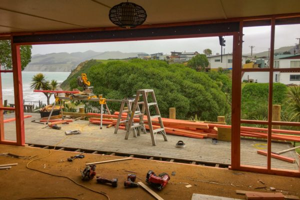 Interior photo looking out at Sandy Bay through new timber framing by Code Construction for renovation project