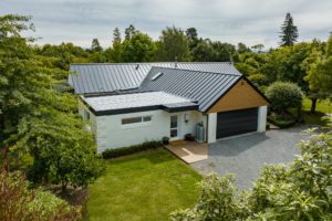 Drone photo of completed renovation project in Fernside Rangiora. Photo shows garage with wooden facade and new roof over house and garage