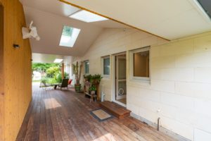 Covered outdoor area renovated by Code Construction, completed with wooden panelled feature wall and roof with skylights