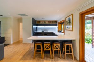 New kitchen renovation completed by Code Construction. Large white bench space with breakfast bar and LED lighting