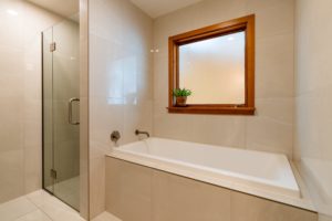 Completed bathroom renovation project by Code Construction showing large deep bath and modern shower