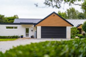 Completed renovation project by Code Construction, showing new roof on house and garage and new windows and doors